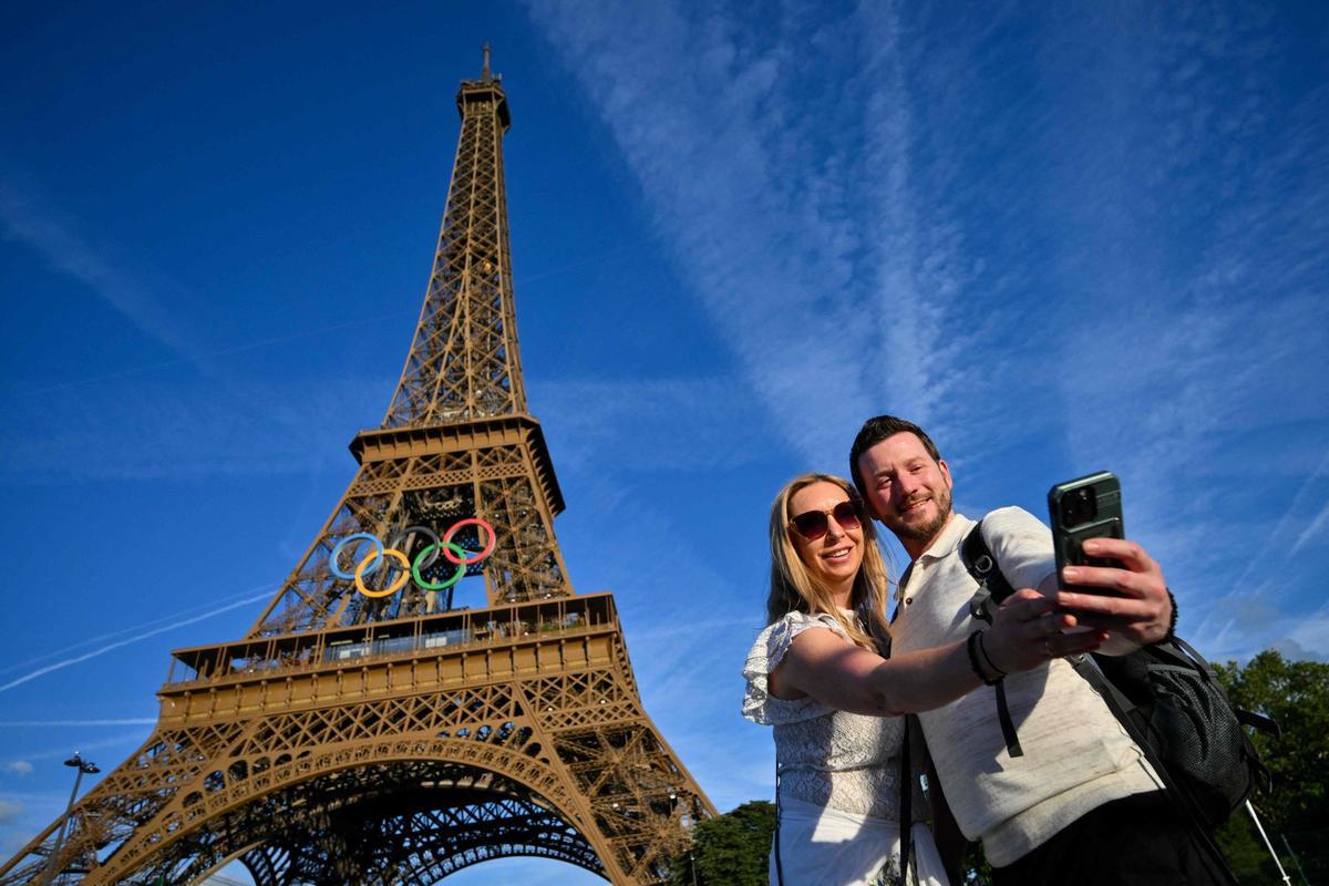 Dos turistas se fotografían con la torre Eiffel de fondo