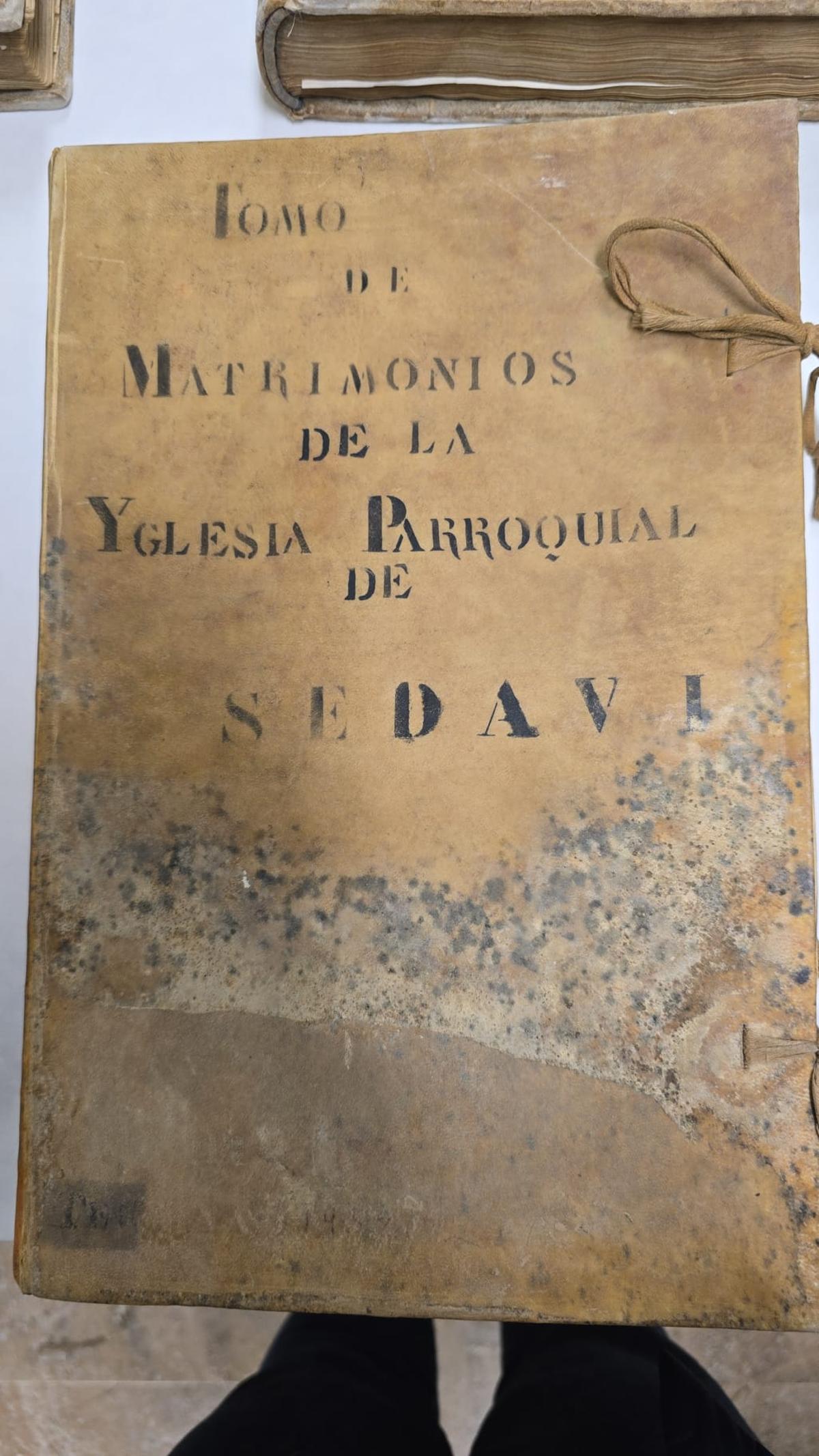 Uno de los tomos parroquiales rescatados del barro.