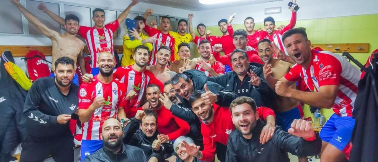Jugadores y cuerpo técnico del Don Benito celebran la victoria en el vestuario del Municipal Villanovense.