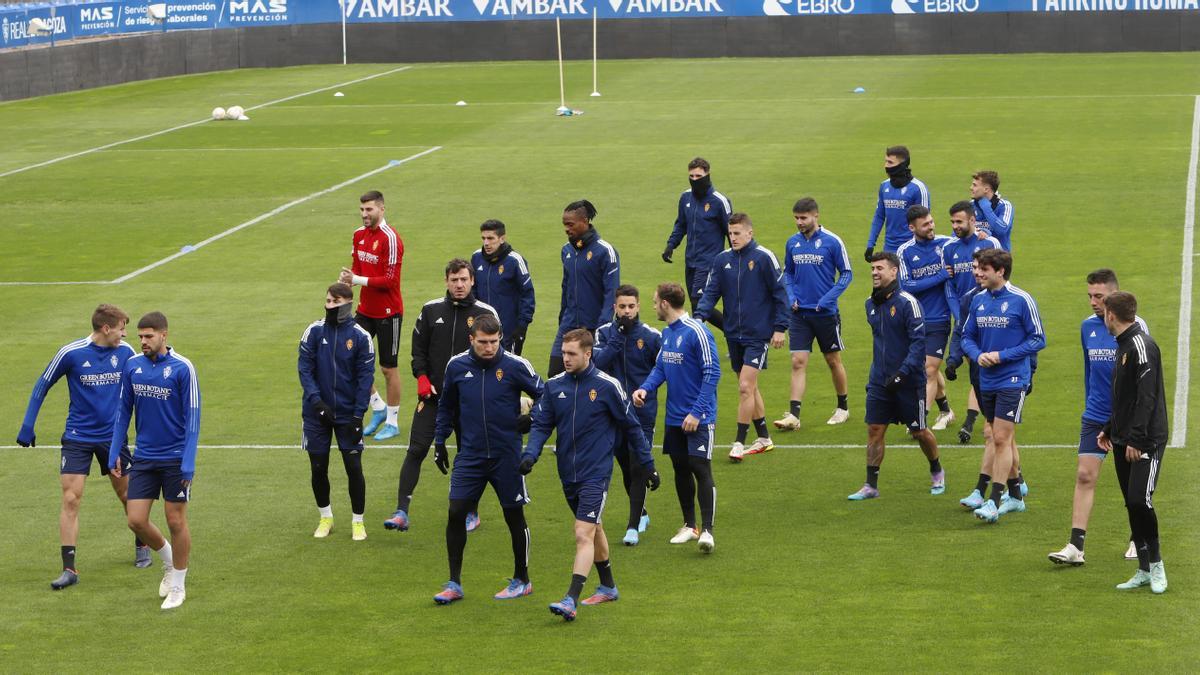 Los jugadores zaragocistas realizan carrera continua en el entrenamiento en La Romareda de este viernes.