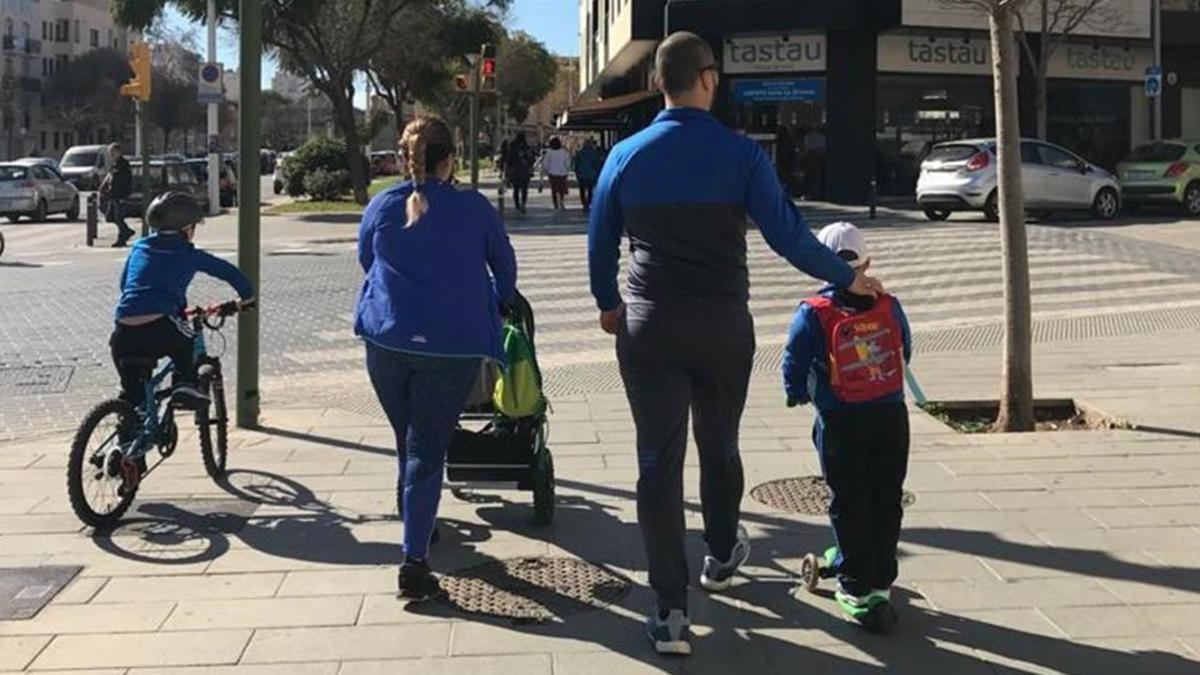 Unos padres pasean junto a sus tres hijos en una avenida de Palma de Mallorca.