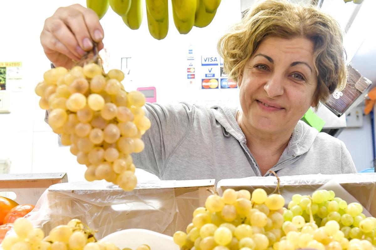 Beatriz Quintero muestra la uvas de su puesto Frutas, Verduras Quintero en el Mercado Altavista.