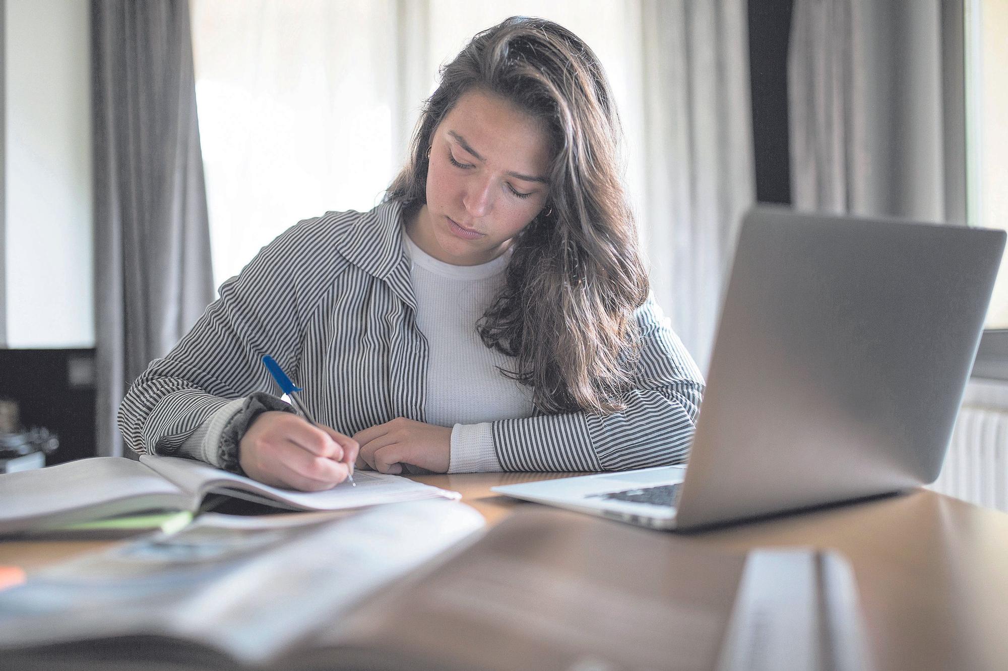 Una estudiante se prepara en casa para un examen