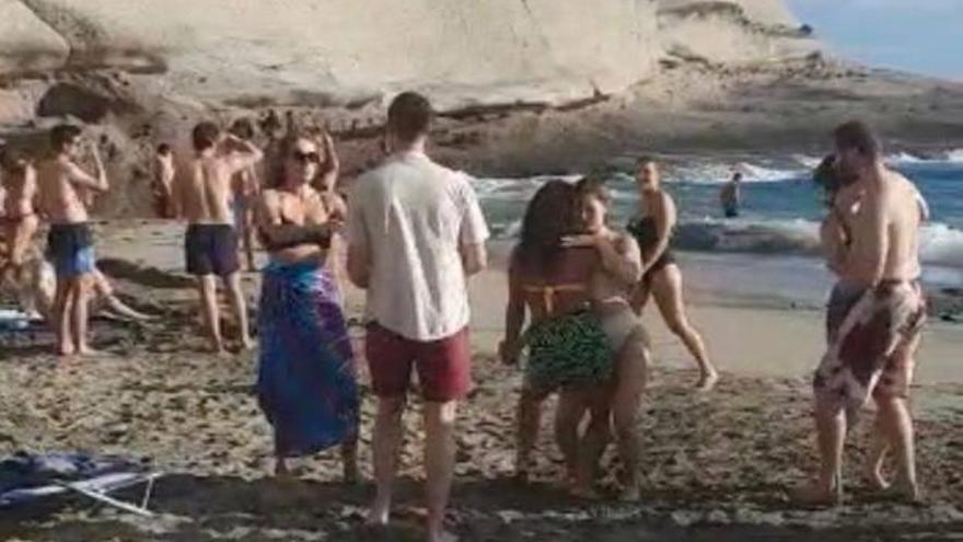 Multitudinaria fiesta con jóvenes bailando sin mascarilla en una playa de Canarias