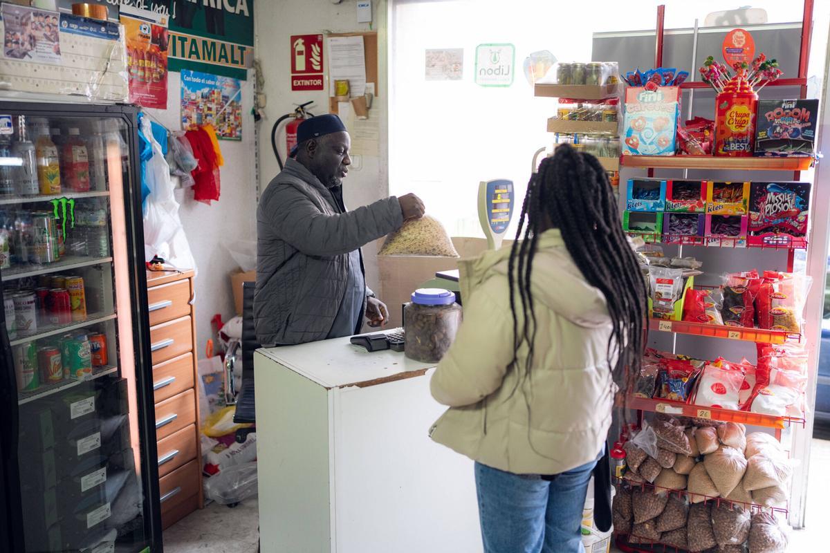 Clientes en la Botiga África regentada por Mamadou Sanoussi, que lleva 26 años en España.