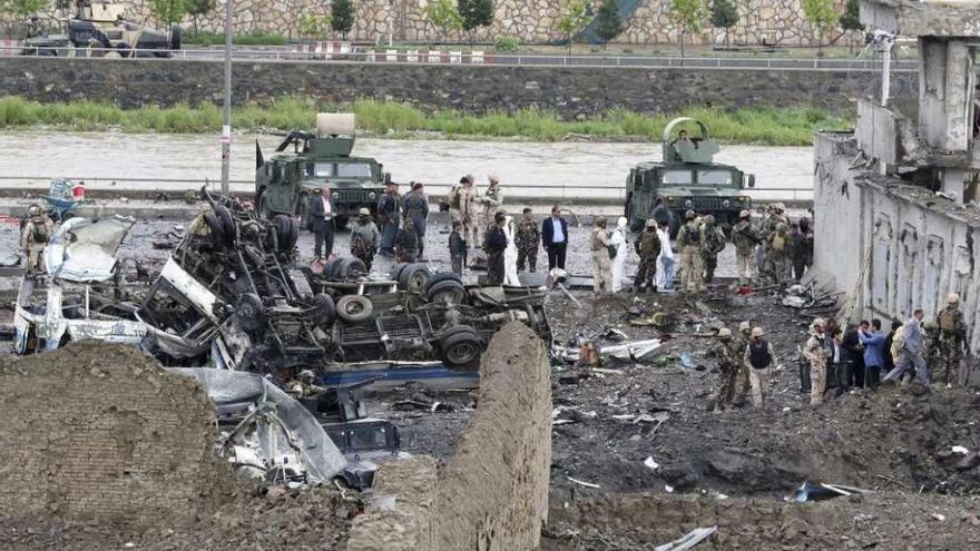 Agentes inspeccionan el escenario del atentado de Kabul, con el camión bomba a la izquierda. // Efe