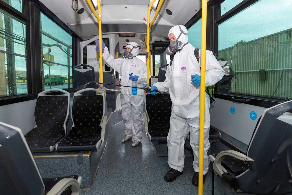 Trabajadores desinfectan un autobús para evitar el contagio del coronavirus.