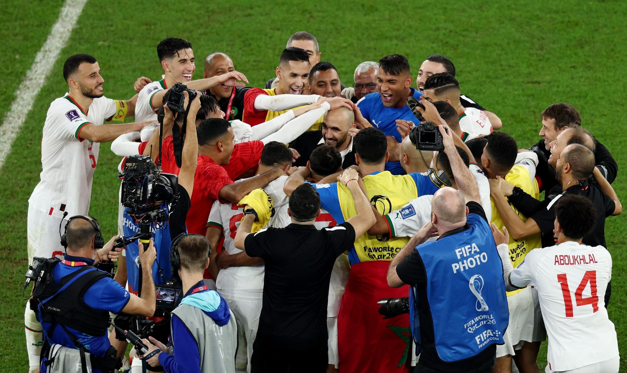 Los jugadores de Marruecos celebran la clasificación para octavos con Walid Regragi.