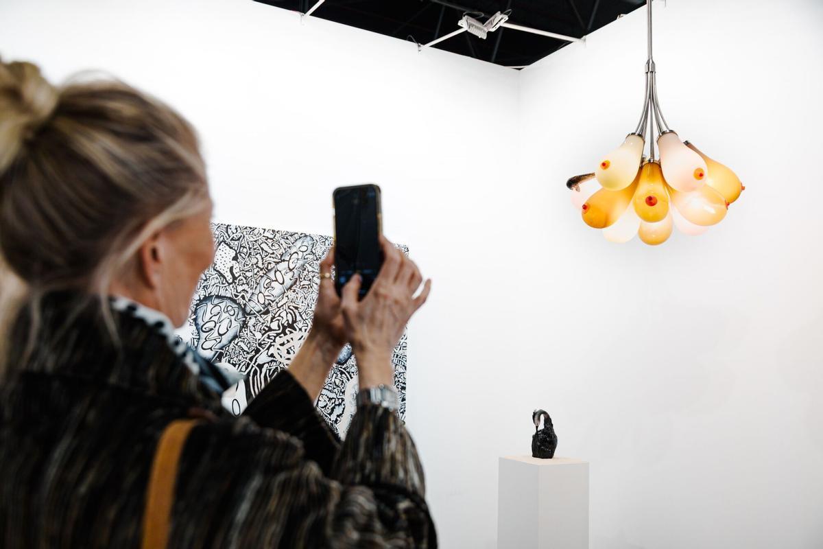 Una mujer fotografía una obra en la feria ARCO Madrid 2025. Una mujer fotografía una obra en la feria ARCO Madrid 2025.