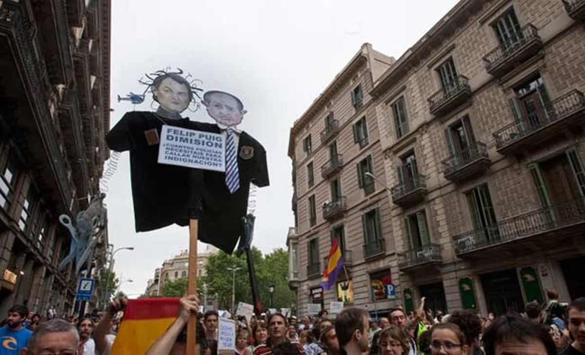Un dels cartells passejats ahir durant la manifestació dels indignats demanava la dimissió del conseller d’Interior, Felip Puig.