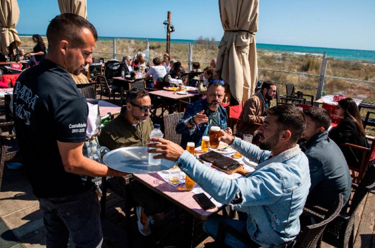 Un camarero sirve un pedido en un establecimiento de playa. 