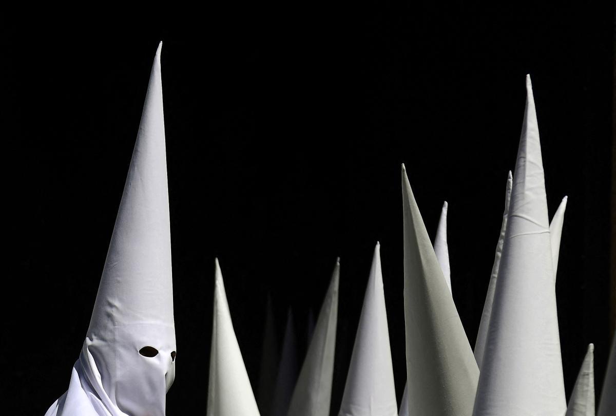 Penitentes de la hermandad de La Paz participan en la procesión del Domingo de Ramos en Sevilla