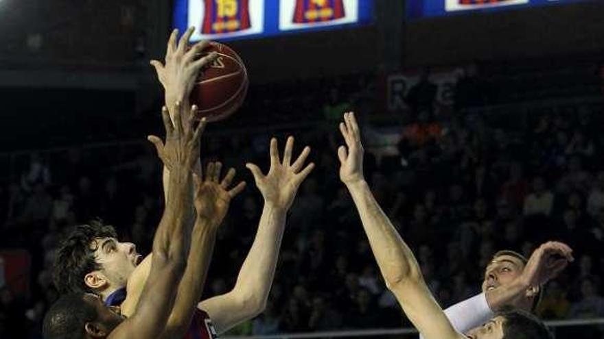 Mickeal y Tomic, del Barça, cogen un rebote ante Rudez. // Toni Garriga