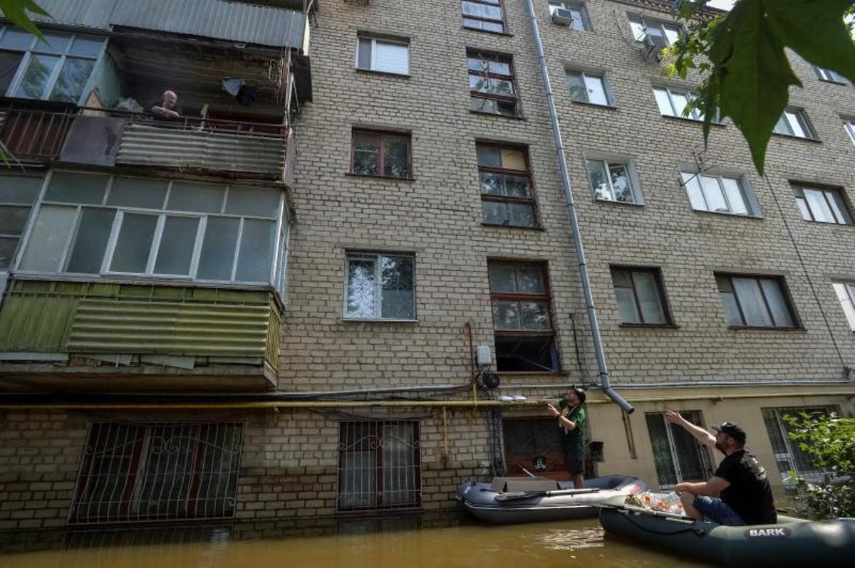 Los voluntarios entregan alimentos a los residentes locales en un área inundada, en medio del ataque de Rusia a Ucrania, en Kherson