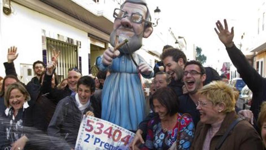 Los vecinos de Manises y afiliados del PP de Manises, donde ha tocado íntegramente el segundo premio del sorteo extraordinario de Navidad, con un ninot de Mariano Rajoy.