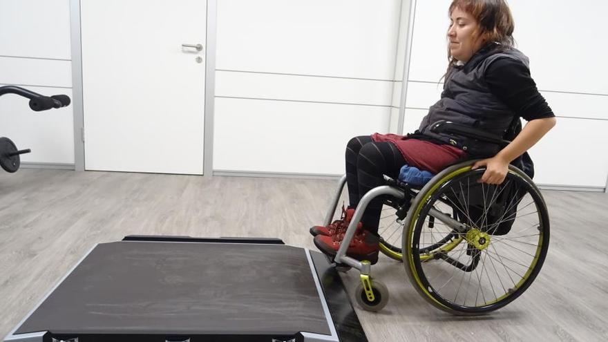 Una usuària de cadira de rodes prova la nova balança electrònica, instal·lada al centre Sirius