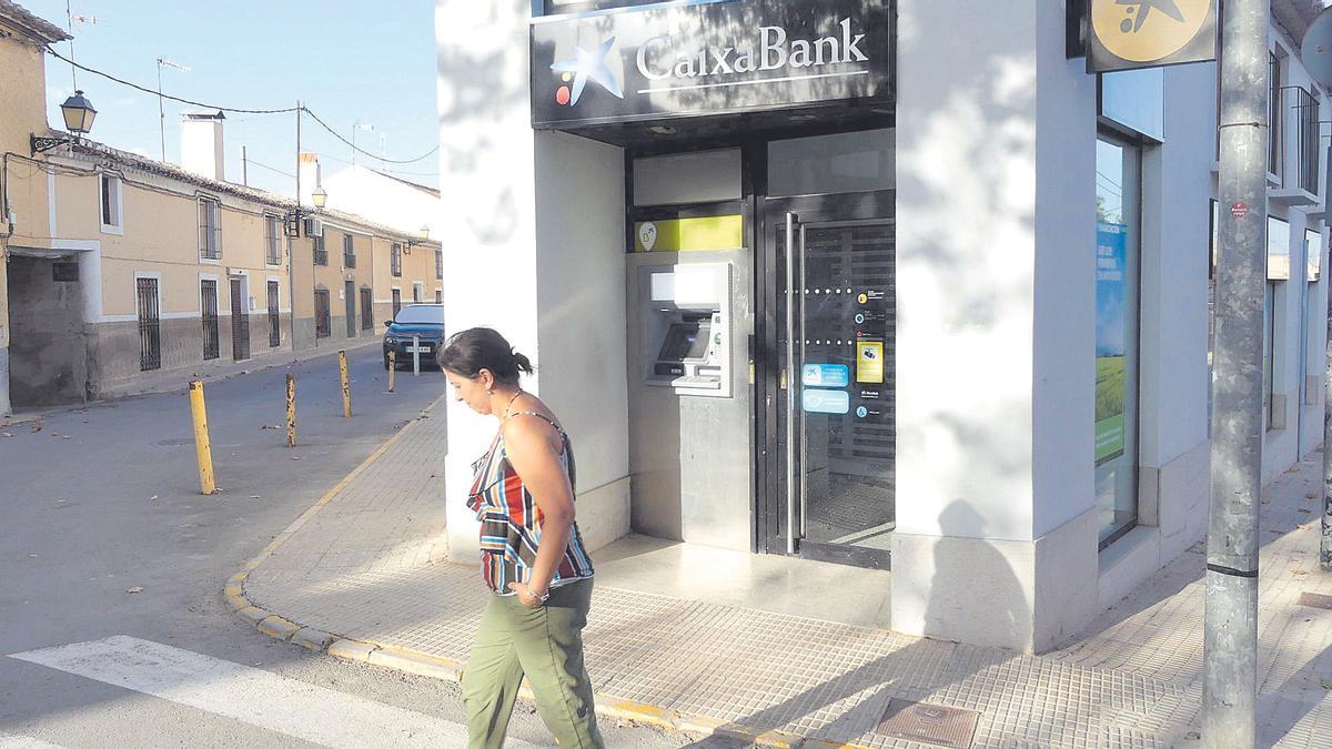 Una mujer pasa ante una oficina bancaria de Barranda, en Caravaca.