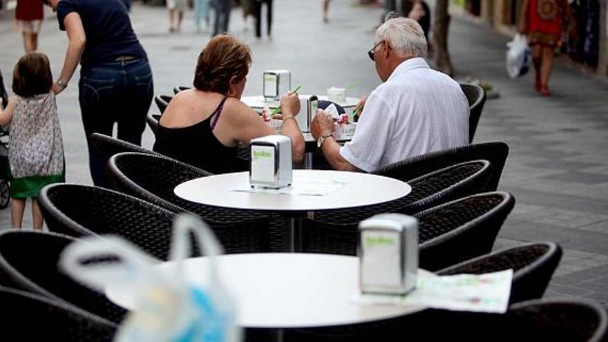 Una pareja sentada en una de las numerosas terrazas que se instalan en la vía pública de Benidorm prácticamente durante todo el año. En este caso, en la calle Alameda.