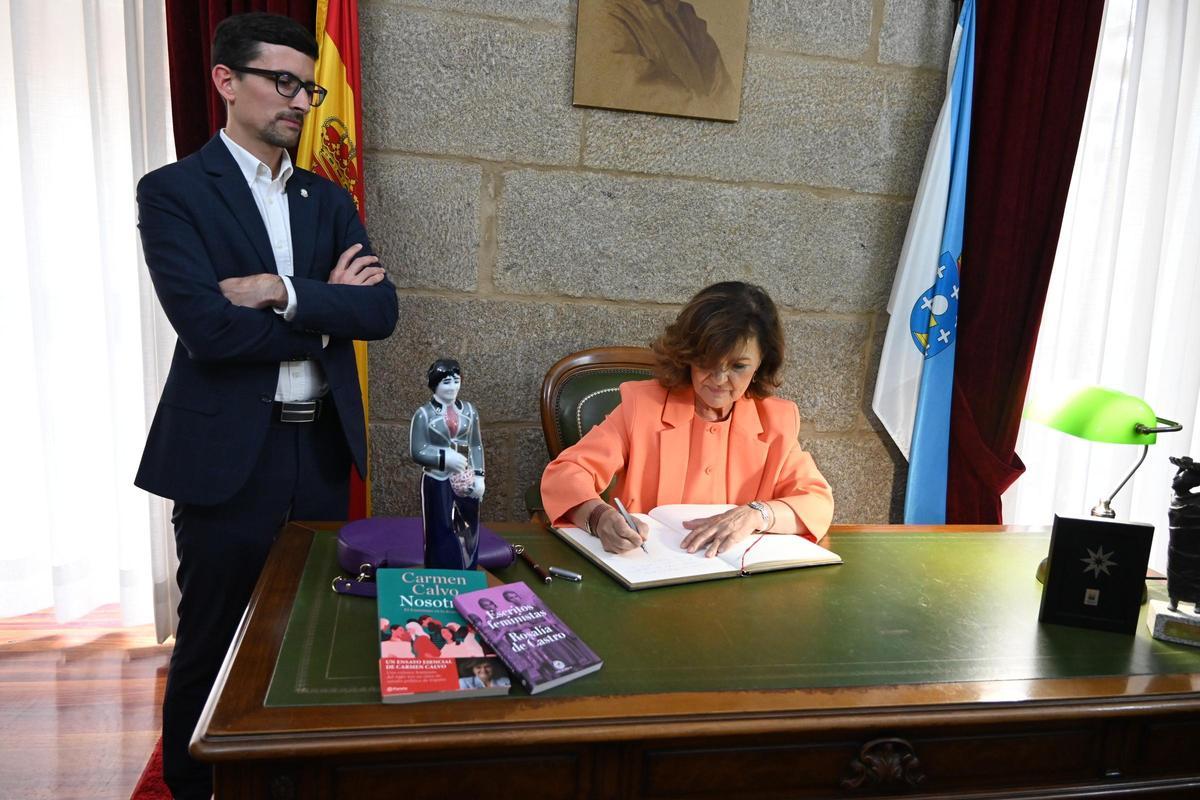 Carmen Calvo firma en el Libro de Honra de Padrón con el alcalde Anxo Arca a su lado