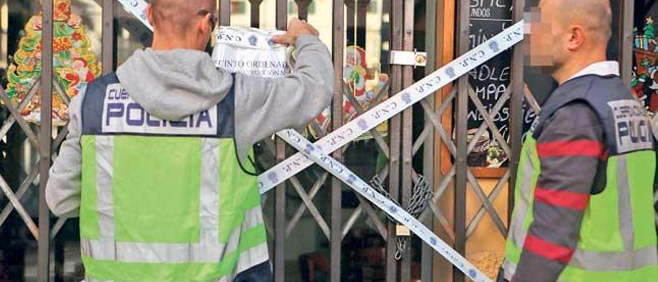 Dos policías nacionales clausuran un restaurante en Palma el pasado mes de diciembre.