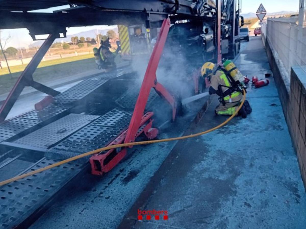 Els bombers apagant l'incendi del remolc d'un camió a Vilamalla.