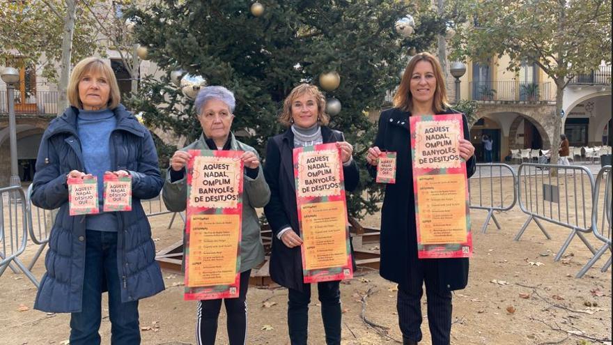 D'esquerra a dreta, dues de les membres de la coral Veus de l'Estany; la presidenta de l'Associació Banyoles Comerç i Turisme; i la regidora de Promoció Econòmica.