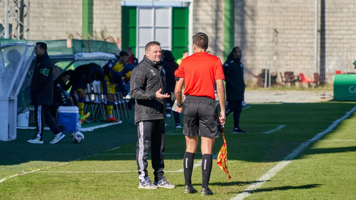 Julio Cobos, entrenador del Cacereño, habla con uno de los árbitros asistentes durante el partido ante el Alcorcón B.