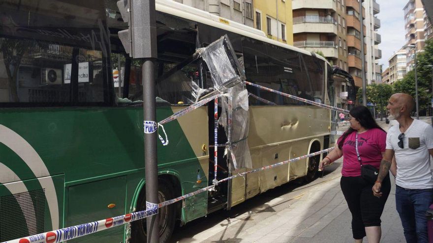 Una pareja de viandantes observa el destrozo del autobús precintado e inmovilizado en la calle de Amargura tras un accidente. | EMMA V. DÍAZ