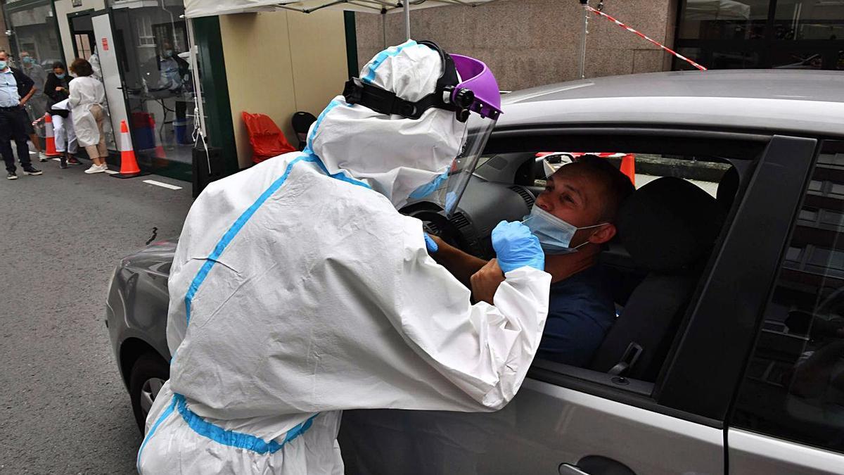 Una sanitaria toma muestras para una PCR en el Covidauto de O Ventorrillo. |   // VÍCTOR ECHAVE