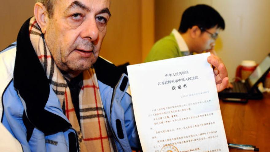 Cándido Rodríguez muestra un documento durante su reclusión en China.  // Zigor Aldama/El País