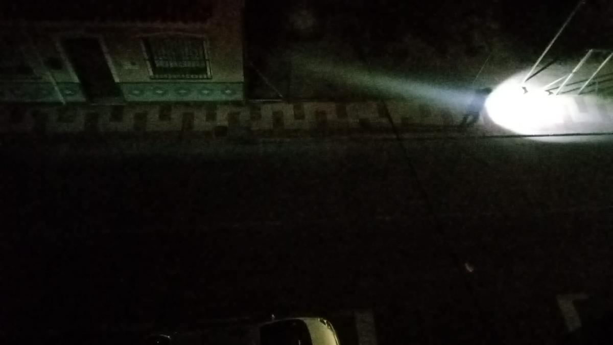 Una persona camina con la lintera del móvil por la calle Labradores de El Campello, ante la oscuridad provocada por los robos de cable y del mal estado de algunas farolas.
