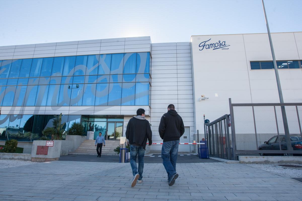 Dos trabajadores entran en las oficinas de Famosa en Alicante.