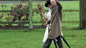 El rey Carlos III de Inglaterra y la reina Camilla saludan con la mano tras asistir a un servicio religioso en la iglesia de Santa María Magdalena, en la finca de Sandringham, en el este de Inglaterra, el 11 de febrero de 2024.