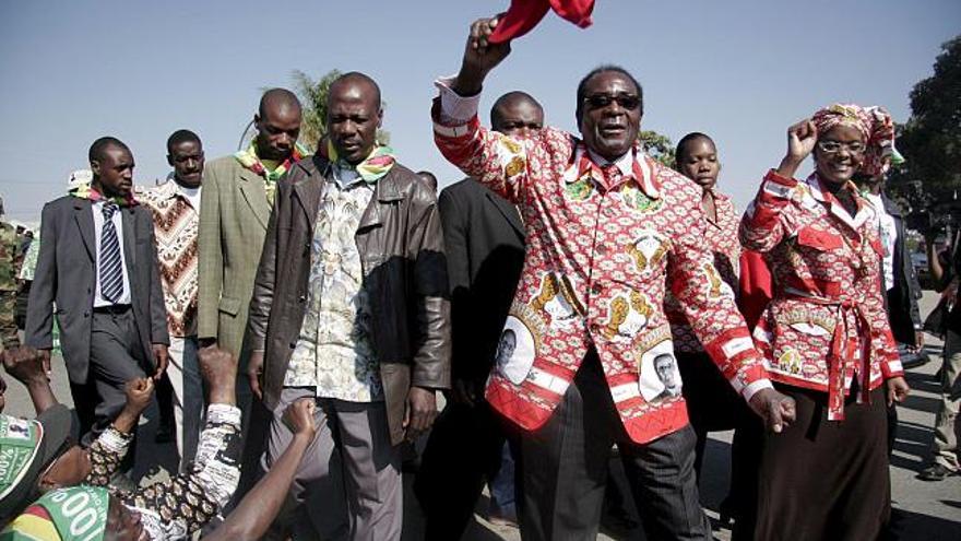 El presidente de Zimbabue Robert Mugabe (c) participa en el último mítin de su campaña electoral en Chitungwiza, Zimbabue en el que lanzó una nueva oferta para negociar con el partido opositor Movimiento para el Cambio Democrático (MDC) tras la celebración de las elecciones presidenciales del próximo viernes.