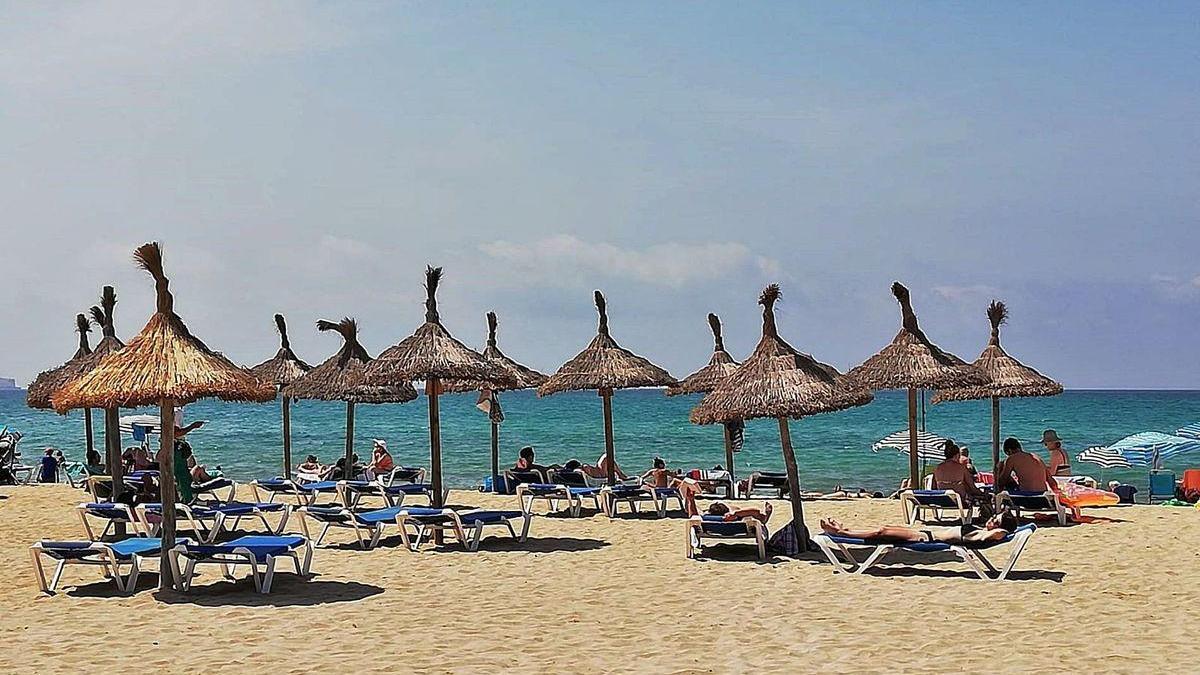 Turistas en hamacas en la playa de Palma de Mallorca.