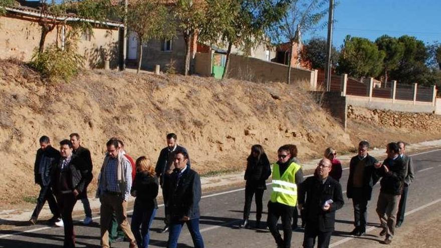 Las autoridades caminan por la carretera reparada.