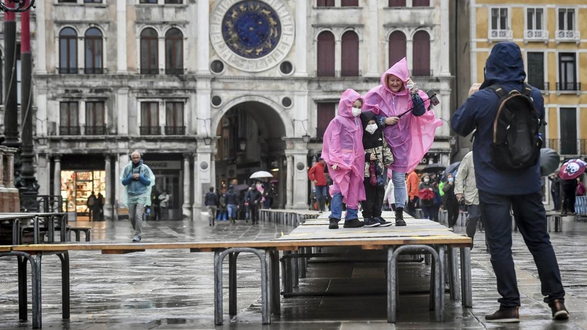 Unas niñas, sobre una de las pasarelas colocadas en previsión de inundaciones, el sábado en Venecia.