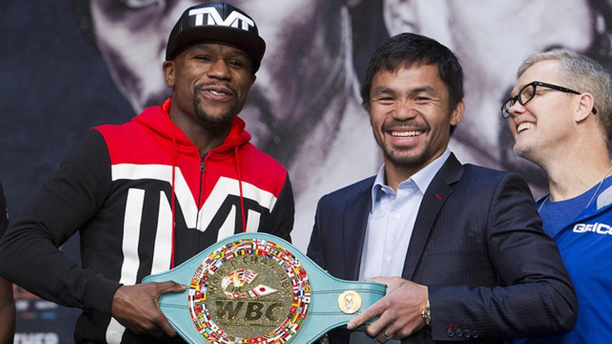 Floyd Mayweather y Manny Pacquiao sostienen el cinturón del campeón del peso welter, en Las Vegas