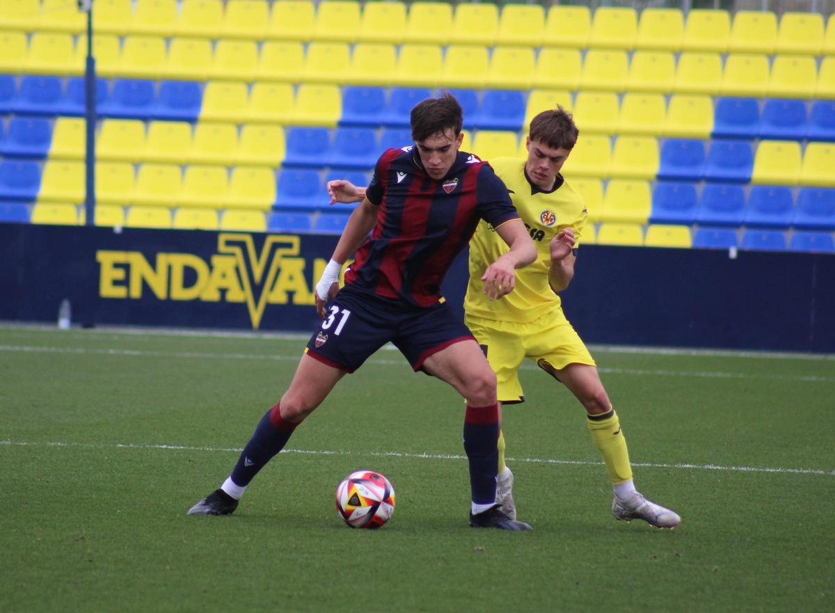 El delantero del Levante B, Carlos Espí, pugna un balón con el mediocentro amarillo Adri Ruiz.