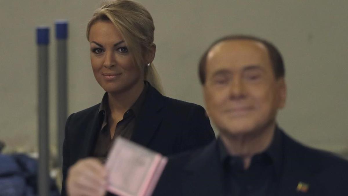 Berlusconi (derecha), flanqueado por su novia actual, Francesca Pascale, en el momento de votar en el referéndum, en Roma, este domingo.