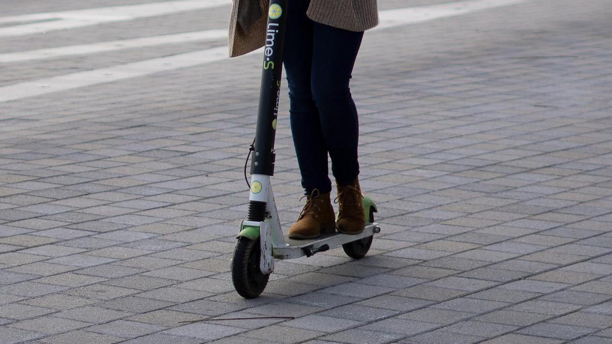 Una mujer circulando en patinete.