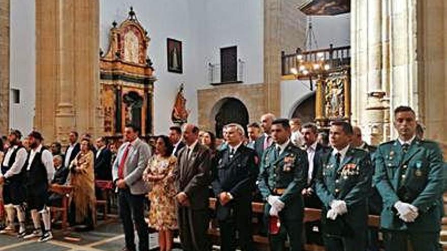 Autoridades, guardias civiles y vecinos durante la eucaristía.