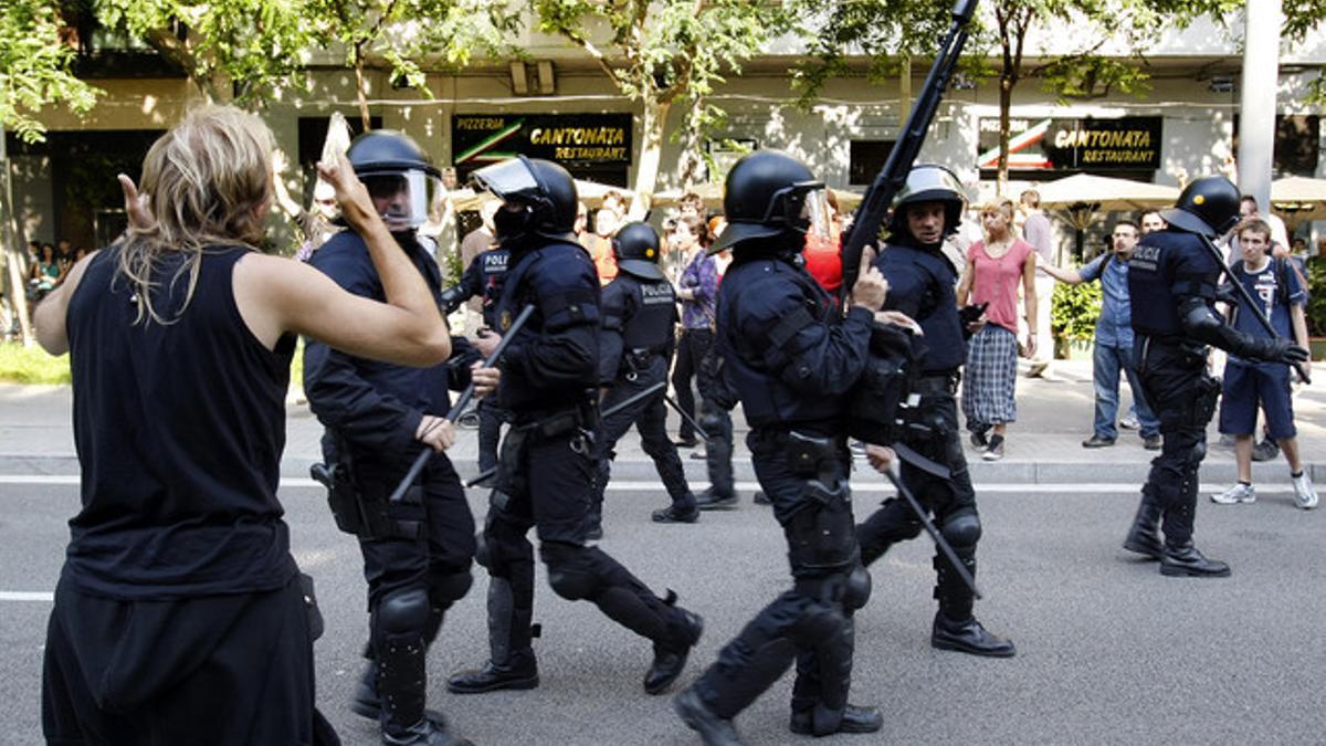 Los mossos intervienen frente a los indignados que quieren frenar el debate sobre los recortes en el Parlament, en junio del 2011.