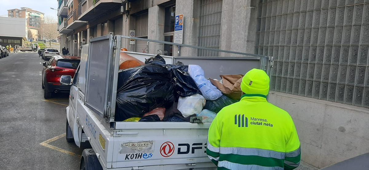 Personal de neteja transportant deixalles dipositades fora dels contenidors