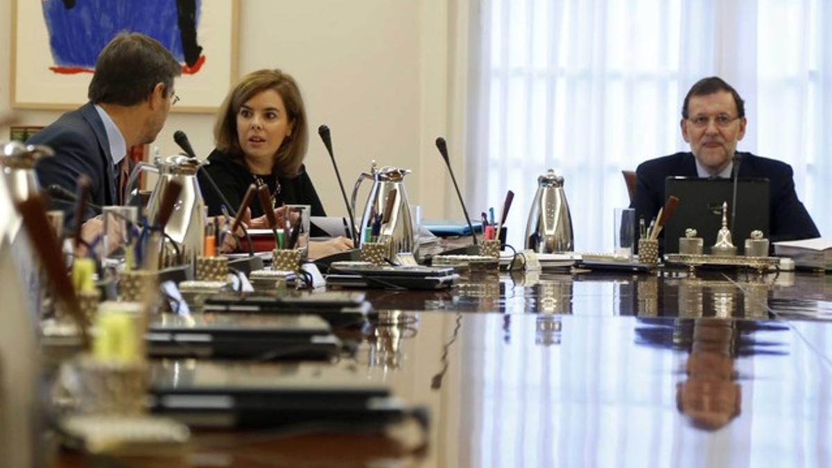 Rajoy, el pasado día 3, durante el Consejo de Ministros, con la vicepresidenta Sáenz de Santamaría y el ministro de Justicia Catalá hablando.