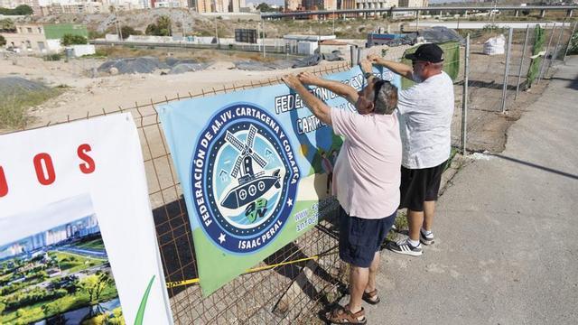 Los vecinos cuelgan carteles junto a la parcela contaminada en Los Mateos, ayer.