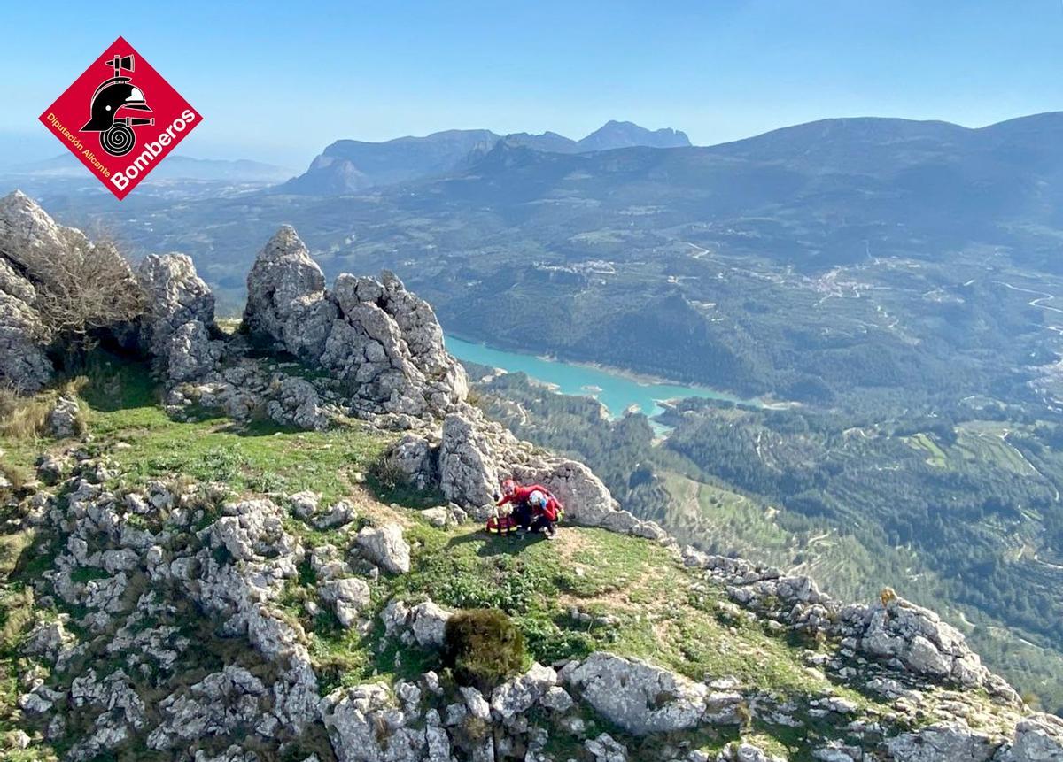 Los especialistas del grupo de rescate atienden al senderista. Espectacular imagen de esta cima de la Marina Alta