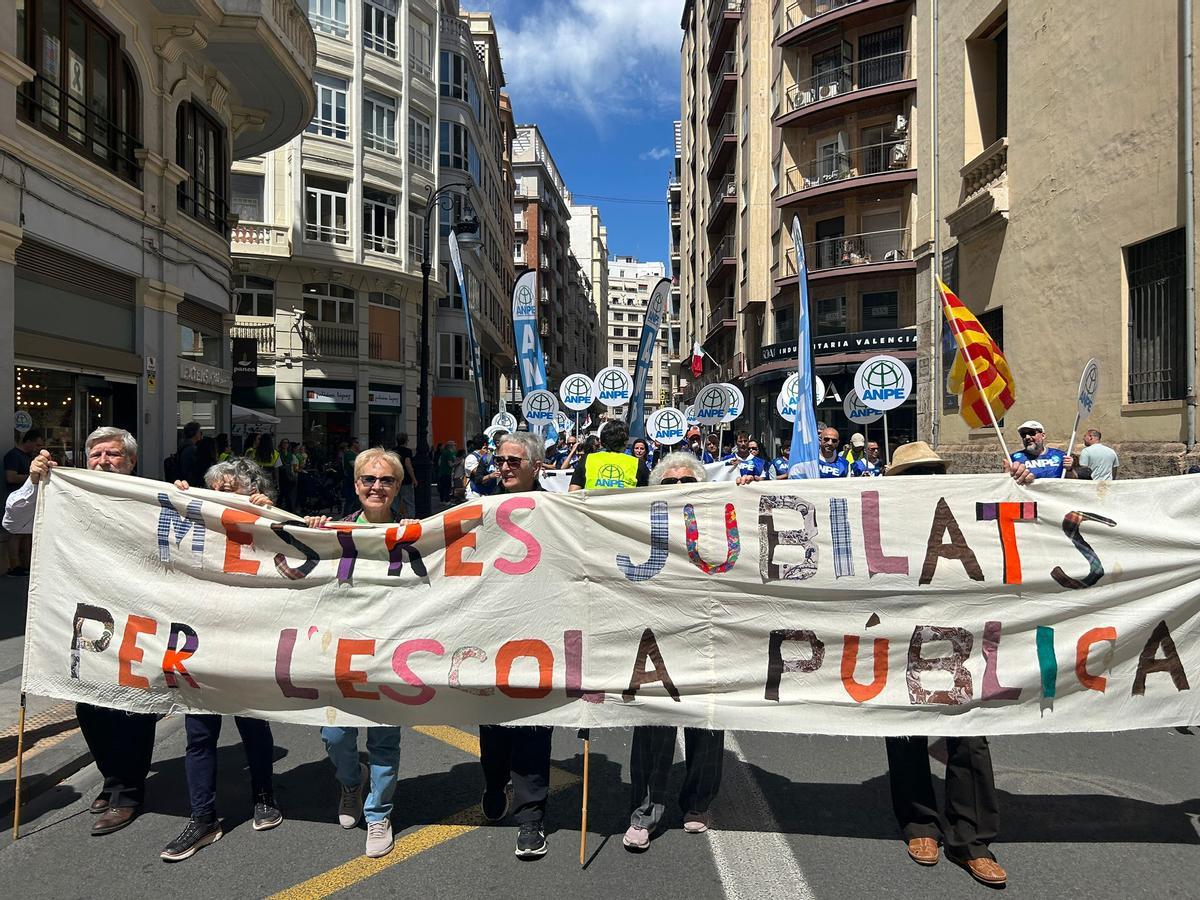 Inma y sus compañeros con la pancarta que indica que son maestros jubilados en la manifestación de docentes en València