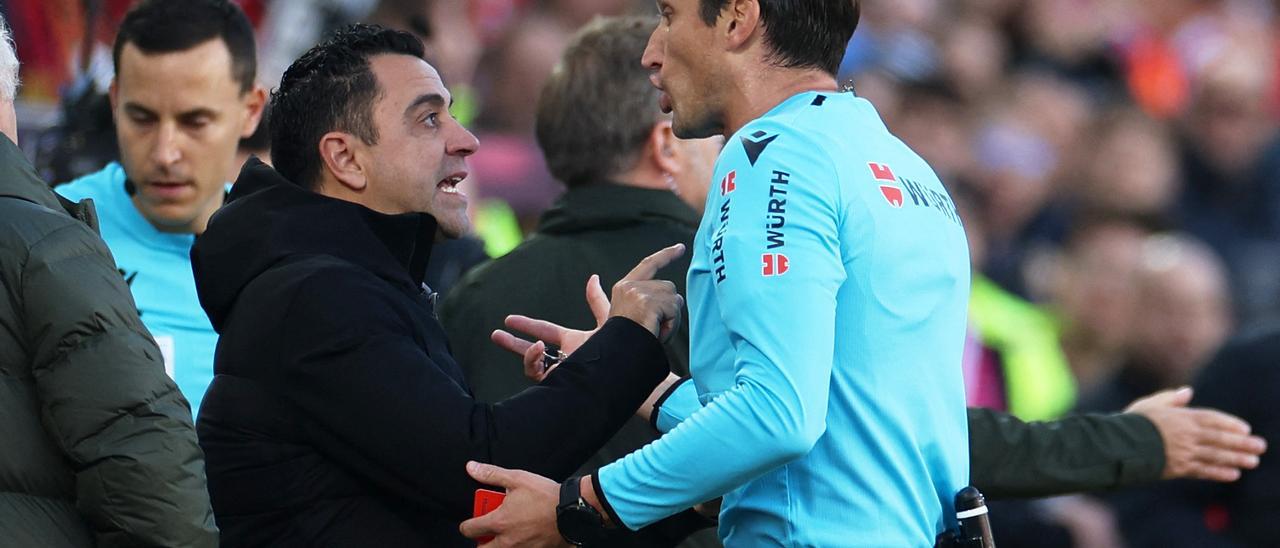 Xavi Hernández y José Luis Munuera Montero durante el partido