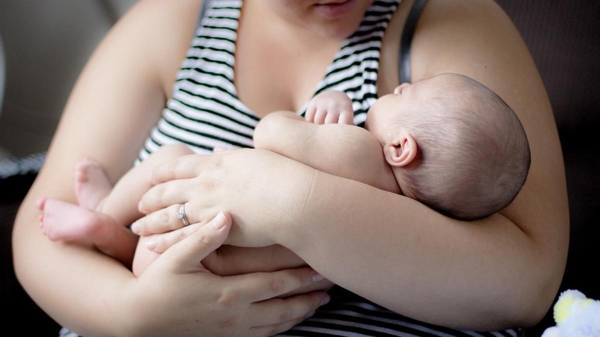 Una madre sostiene a su bebé en brazos.